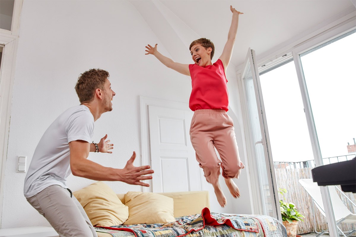 Ein Mann und eine Frau jubeln in einer Wohnung. WestLotto-Gewinnerbilanz