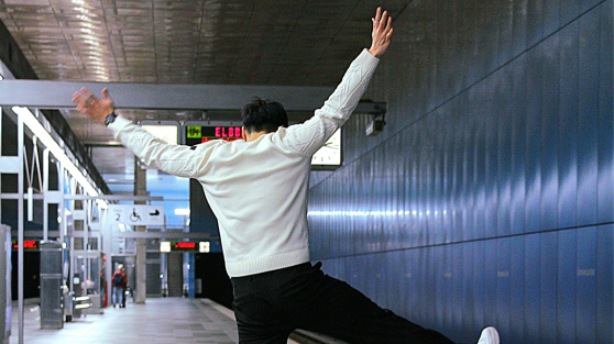 Mann freut sich am U-Bahn Gleis