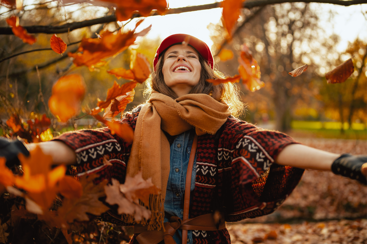 Frau freut sich im Herbstlaub