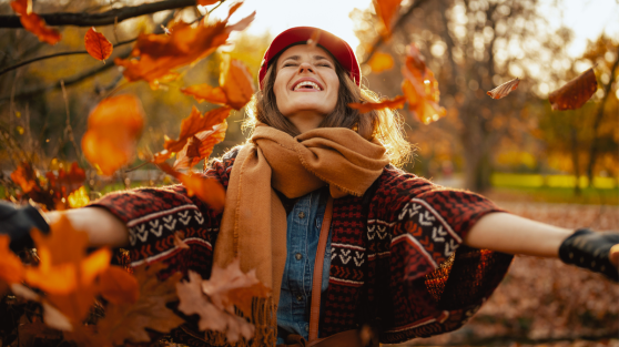 Frau freut sich im Herbstlaub