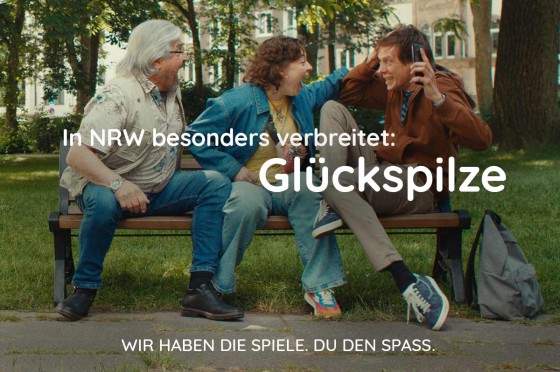 Drei Menschen aus NRW sitzen auf einer Parkbank und jubeln | WestLotto 