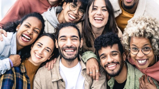 Mehrere Personen stehen eng beieinander und lachen in Kamera | WestLotto LOTTO-Spielgemeinschaften