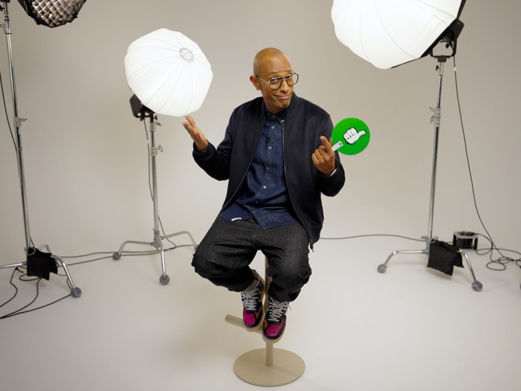 Amiaz - Moderator der Local Hero Bingo-Show - sitzt in einem Studio auf einem Barhocker. WestLotto