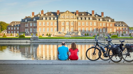 Zwei Radfahrer sitzen vorm Schloss Nordkirchen | WestLotto Ausflugstipps NRW