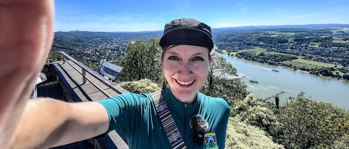 Selfie einer Radfahrerin vor Rhein-Panorama | WestLotto Radtour des Monats