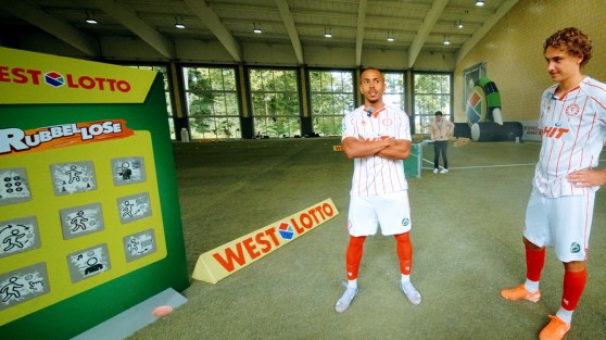 Zwei Spieler der Regionalliga West stehen vor überdimensionalem WestLotto-Rubbellos