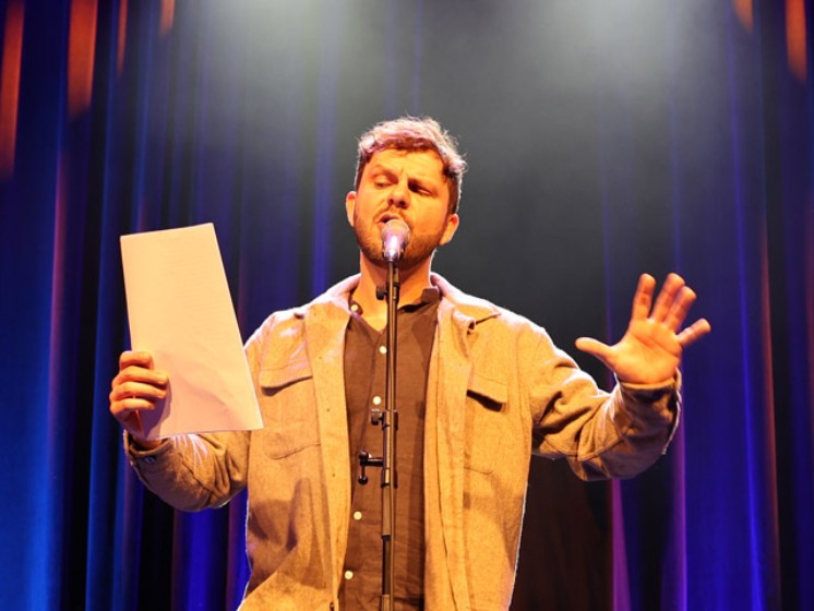 Mann vor Mi­k­ro­fon | WestLotto Poetry-Slam